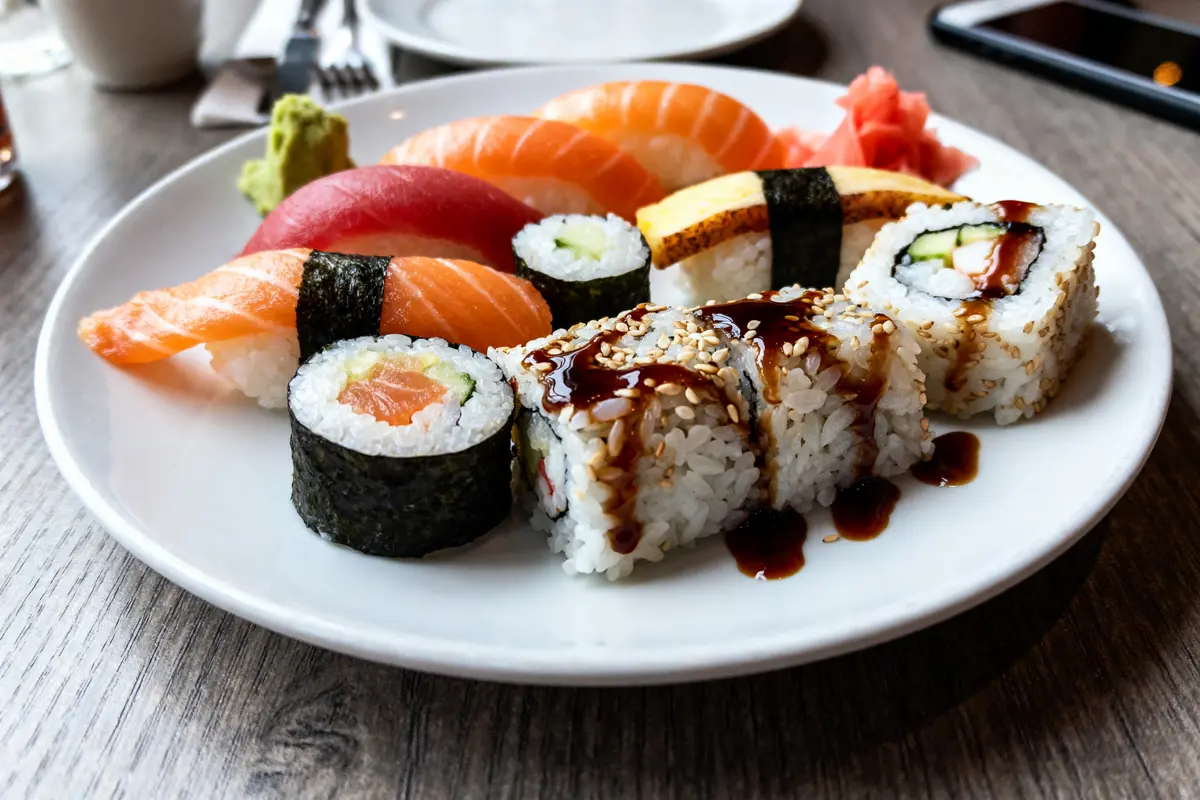 Assortiment coloré de sushis variés avec sauce et gingembre, focus sur calories des sushis