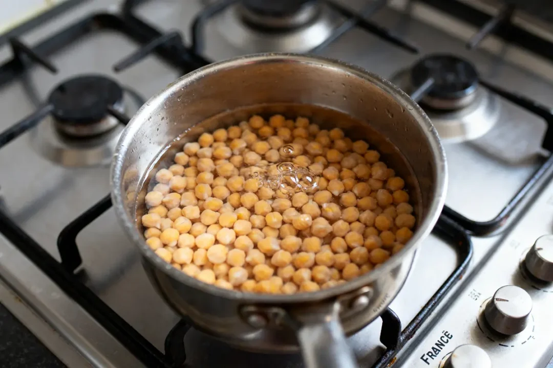 Pois chiches bouillant à la casserole sur cuisinière pour temps de cuisson des pois chiches