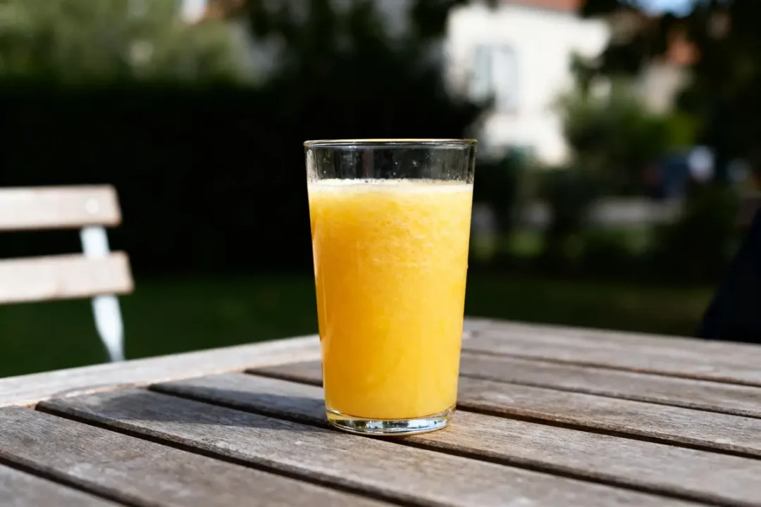 Verre de jus d’ananas sur table en bois exprimant les bienfaits du jus d'ananas