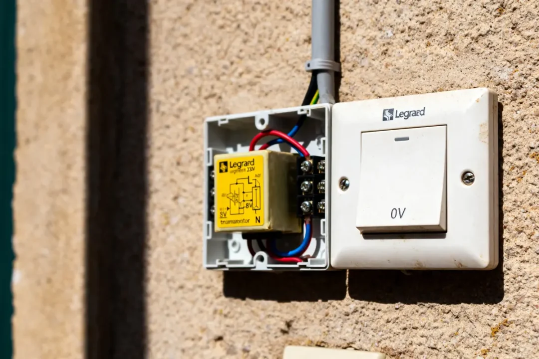 Boîtier ouvert illustrant le schéma de branchement sonnette Legrand 230V avec fils électriques apparents